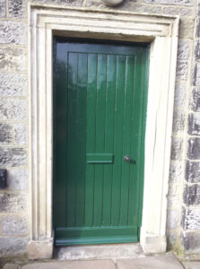 Green door to stone building
